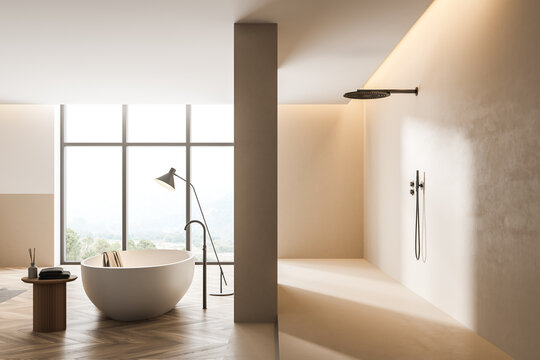 Bathtub and shower in light bathroom interior with window and wooden floor