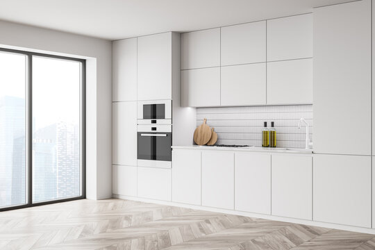 White kitchen interior with cupboards and built in appliances
