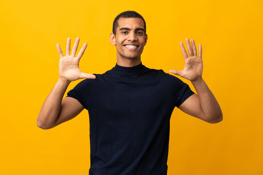 African American man counting numbres over isolated yellow background