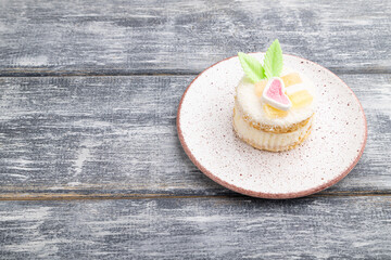 Decorated cake with milk and coconut cream on a gray wooden background. Side view, copy space.