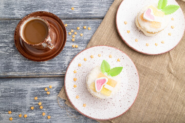 Decorated cake with milk and coconut cream with cup of coffee on a gray wooden background. top view.