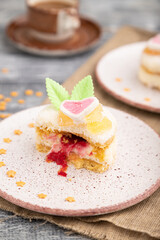 Decorated cake with milk and coconut cream with cup of coffee on a gray wooden background. Side view, selective focus.
