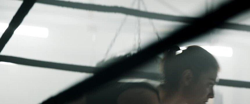 HANDHELD Portrait of tired Caucasian female boxer sits in a ring corner. Shot with 2x anamorphic lens