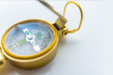 Banner of golden compass isolated, shallow DOF, focus on dial. Compass on a white background. Concept for direction, travel, guidance or assistance.