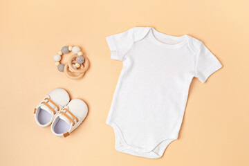 Mockup of white infant bodysuit made of organic cotton with eco friendly baby accessories.  Onesie template for brand, logo, advertising. Flat lay, top view