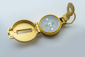 Banner of golden compass isolated, shallow DOF, focus on dial. Compass on a white background. Concept for direction, travel, guidance or assistance.