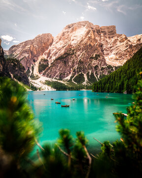 Boats on the Lago di Braies (Pragser Wildsee) with colorful water and mountain in the background, Dolomites, Italy