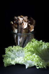 A piece of smoked pilchards in a glass with green salad. High quality photo