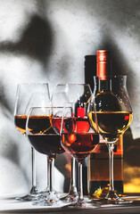 Wines assortment. Red, white, rose wine in wineglasses on gray background. Wine tasting concept....