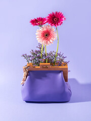 Purple leather fashion handbag with pink gerbera, summer accessory concept - 437748303