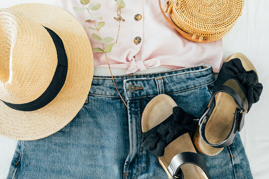 Beauty blog concept. Summer female clothes, accessories. Sandals, denim shirt, top, hat, rattan bag