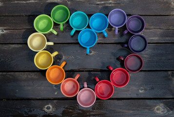 Pride coffee mug arrangement, with a rainbow of colors in a heart shape