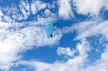 Parachute jumpers on a blue sky background