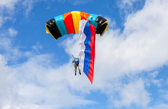 Parachute jumper with flag of Russia on a blue sky