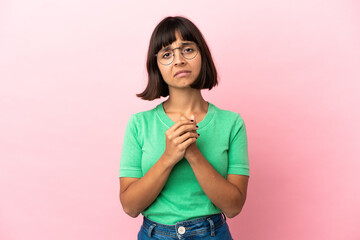 Young mixed race woman isolated on pink background laughing