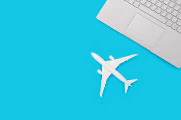 Toy airplane and notebook keyboard on pastel blue background. Flat lay design
