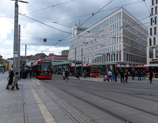 trams and many commuters at the central train station and hub in downtown Bremen