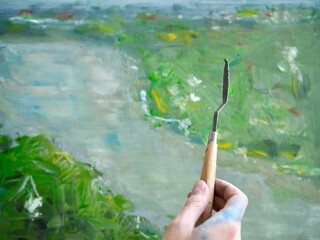 Woman Artist painting abstract oil painting in art studio. Close up photo palette knife in hand on canvas background. Modern art, creativity concept, hobby