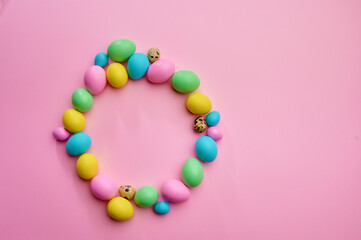 Colorful easter eggs on pink background, top view