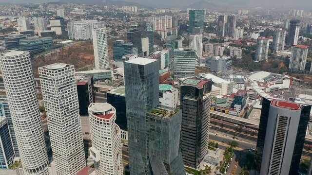 Aerial drone view of large cityscape. Camera tilting down to detail of modern tall Paradox Torre building. Mexico city, Mexico.
