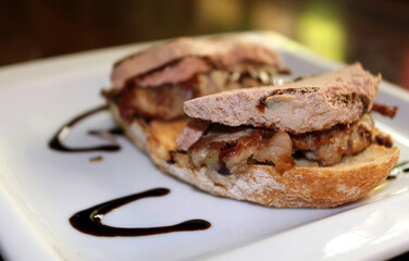 tostada de solomillo de ternera con foie y sirope en plato blanco