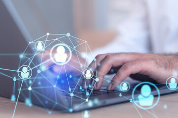 Hands of hr specialist is typing the keyboard in the internet to find the best candidates to create international network in recruitment process. Formal wear. Social media hologram icons.