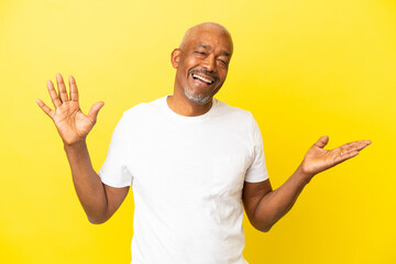 Cuban Senior isolated on yellow background smiling a lot