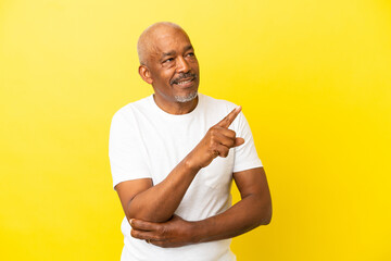 Cuban Senior isolated on yellow background pointing up a great idea