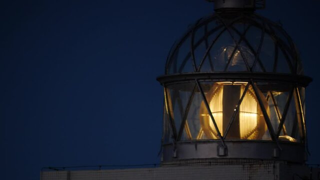 Detail view. Lighthouse with beacon light in the night. Faro Cabo Busto on Asturias coast in Spain. Tourist attraction, place to visit.