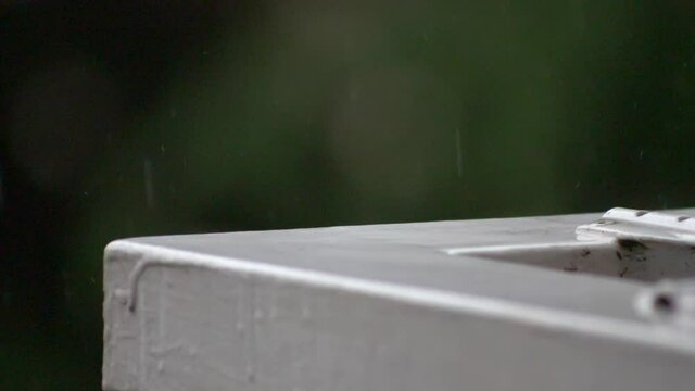 Drop falling on white painted handrail. Super slow motion HD