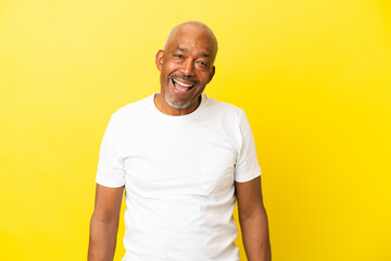 Cuban Senior isolated on yellow background laughing in lateral position