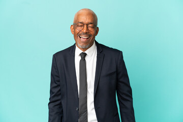 Business senior man isolated on blue background laughing in lateral position