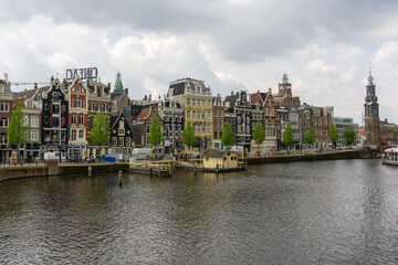 cityscape view of Amsterdam with many historic buildings lining the sides of the Amstel canal