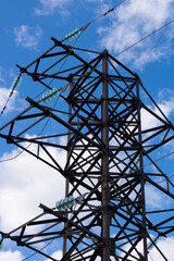 Lattice tower of power lines against blue sky