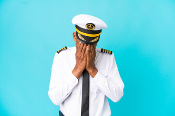 Airplane pilot senior man isolated on blue background with tired and sick expression