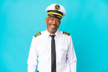 Airplane pilot senior man isolated on blue background laughing in lateral position - obrazy, fototapety, plakaty