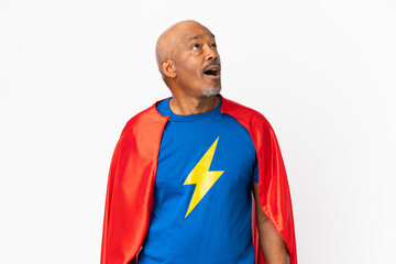 Super Hero senior man isolated on white background looking up and with surprised expression