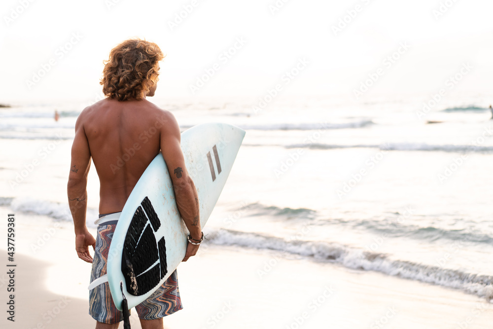 Sticker young caucasian man get up early to doing surf at sunrise