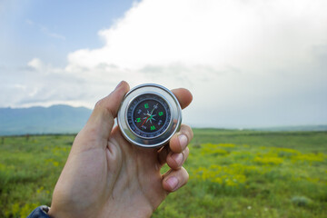 holding a compass on the background of the field