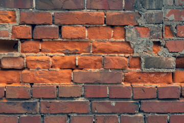 Wall of old red clay bricks. Ruined vintage stone background. Rough aged masonry backdrop. Surface of grunge brick texture for design and decoration. Loft style for exterior and interior decoration