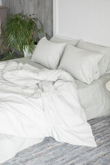 Grey ecologycal linen on bed in modern home interior. Daylight
