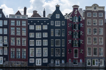 view of the iconic houses on the waterfront at the Damrak in downtown Amsterdam