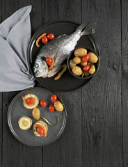 Dorado with new potatoes, zucchini, cherry tomatoes with copy space, top view