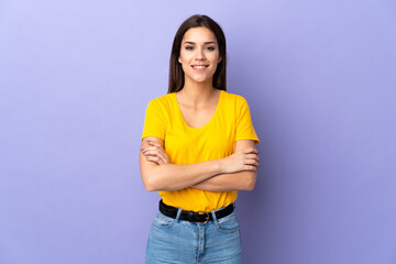 Young caucasian woman over isolated background keeping the arms crossed in frontal position