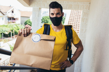 Man in protective mask delivering online grocery order.