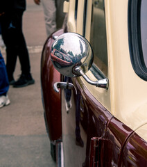 Retro car festival. Rearview mirror on an old retro car. Fragment of the front of a retro car.