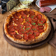 Pepperoni Pizza with Mozzarella cheese, salami, Tomatoes, pepper, Spices and Fresh Basil. Italian pizza