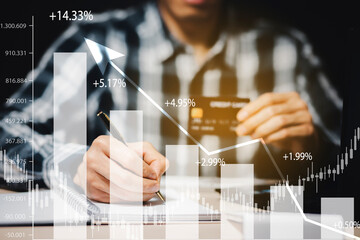 Businessman holding credit card and market graph on the Internet on the laptop computer with credit card, online payment, shopping online, e-commerce, internet banking, spending money concept.