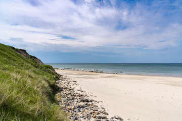 beautiful white sand beach with high grassy sand dunes behind