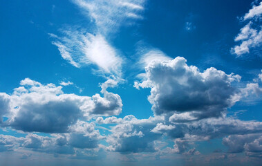 Naklejka na ściany i meble Beautiful contrasting large clouds in blue sky for background